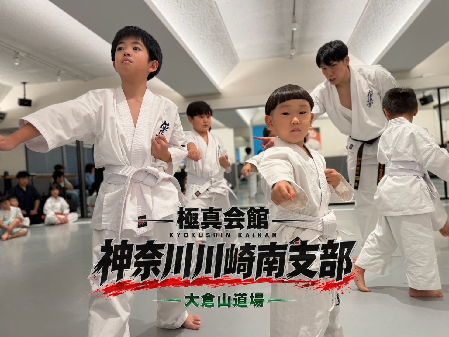 突きの基本移動稽古。前列の幼年が力強く拳を構えている