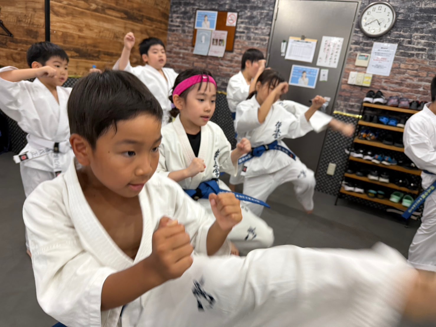 少年部の生徒たちが蹴り技を揃えて稽古している様子