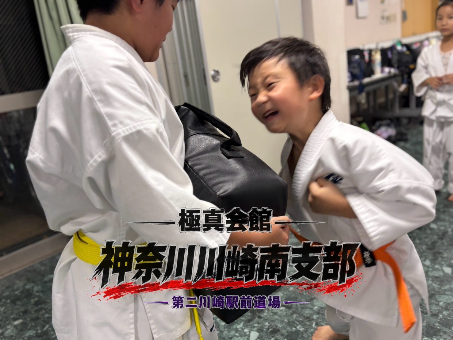 笑顔でミット打ちをする道場生