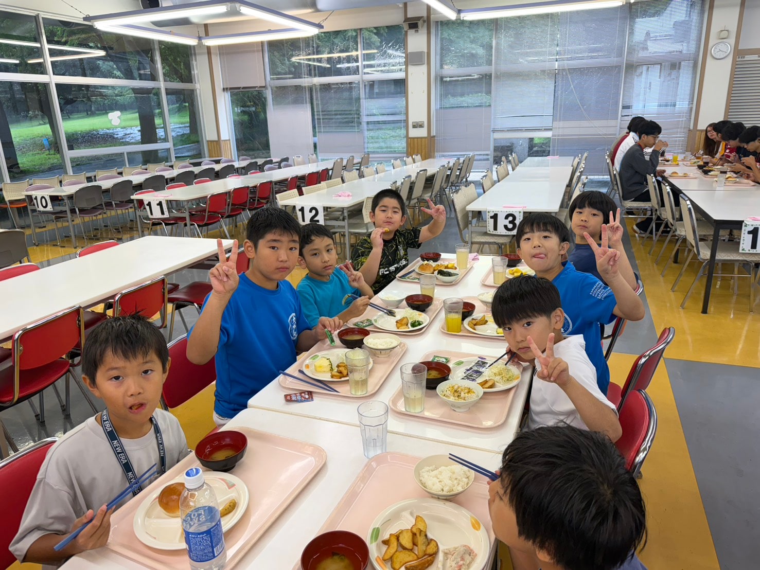 食堂でピースサインをする子どもたち
