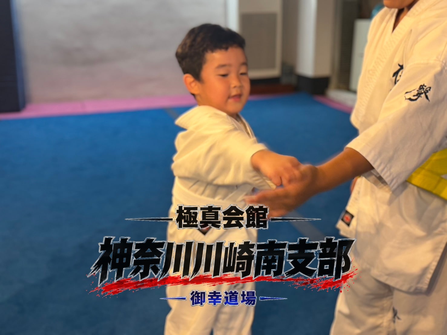 幼年生徒が先輩に手を取ってもらいながら稽古」 class=