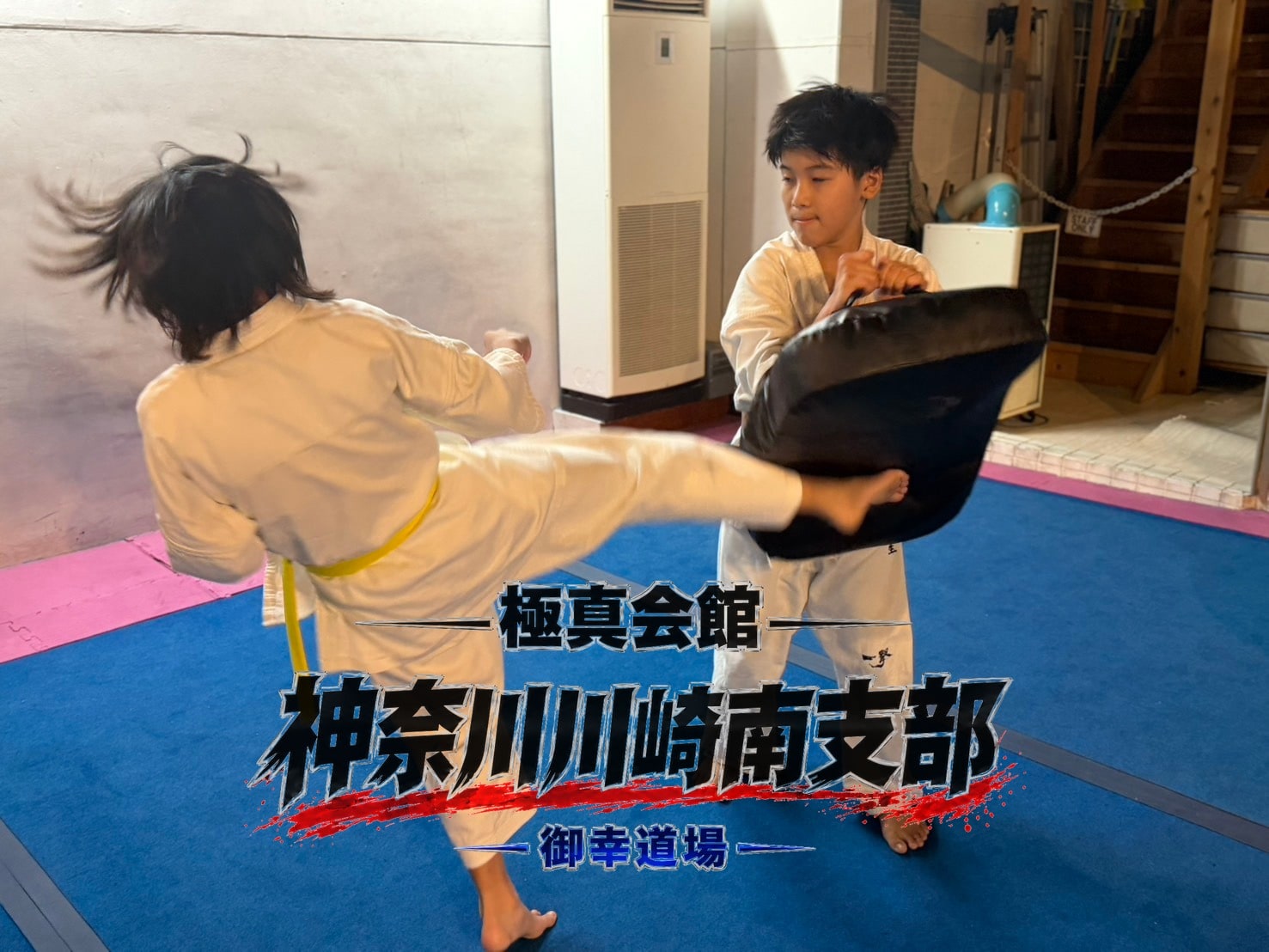 先輩がミットを持ち後輩が蹴り込むミット稽古」 class=