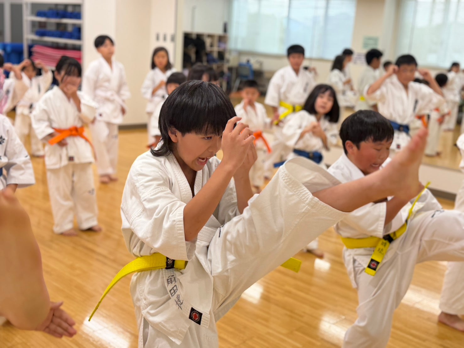 黄帯の道場生が蹴り技の移動稽古に取り組む様子