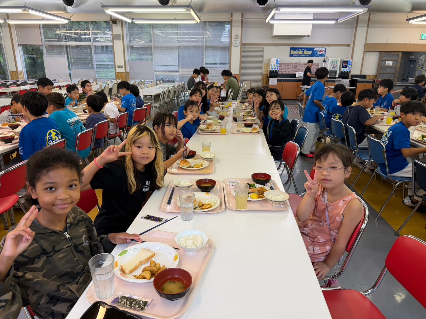 大勢の子どもたちが並んで朝食をとる食堂の様子