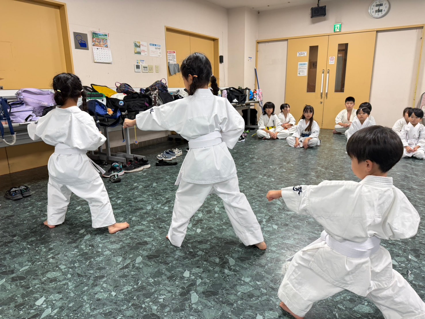 白帯の生徒たちが型の動作を揃えて行う