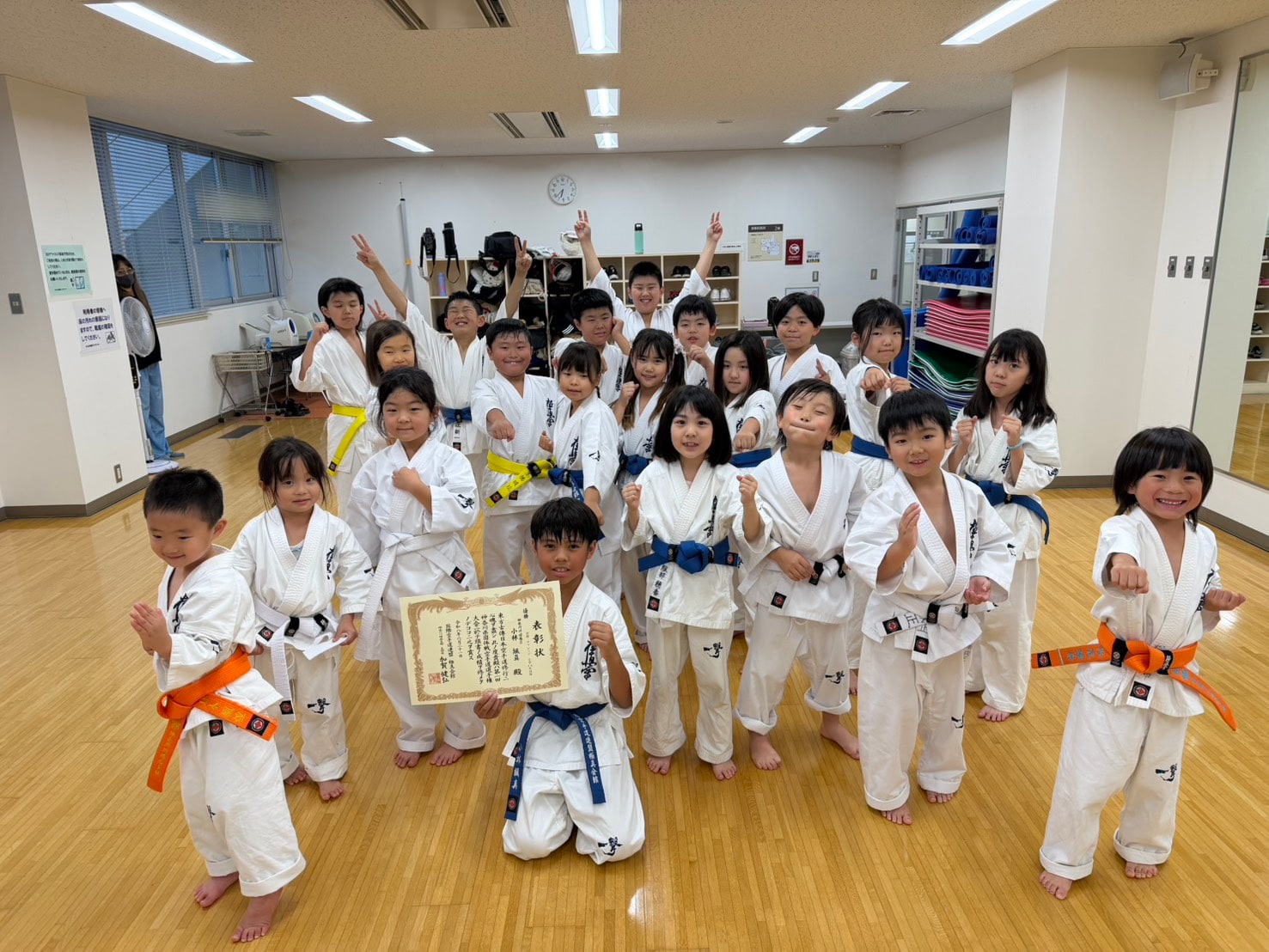表彰状を手に笑顔で集合写真」