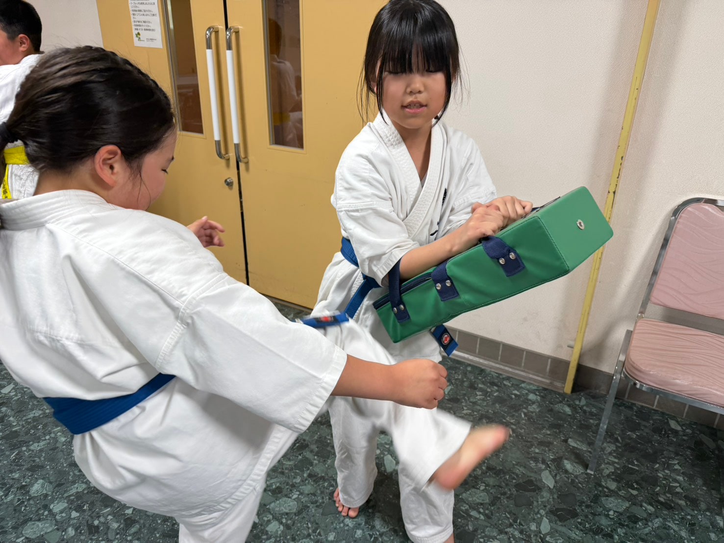 ミットを蹴る稽古をする女子道場生