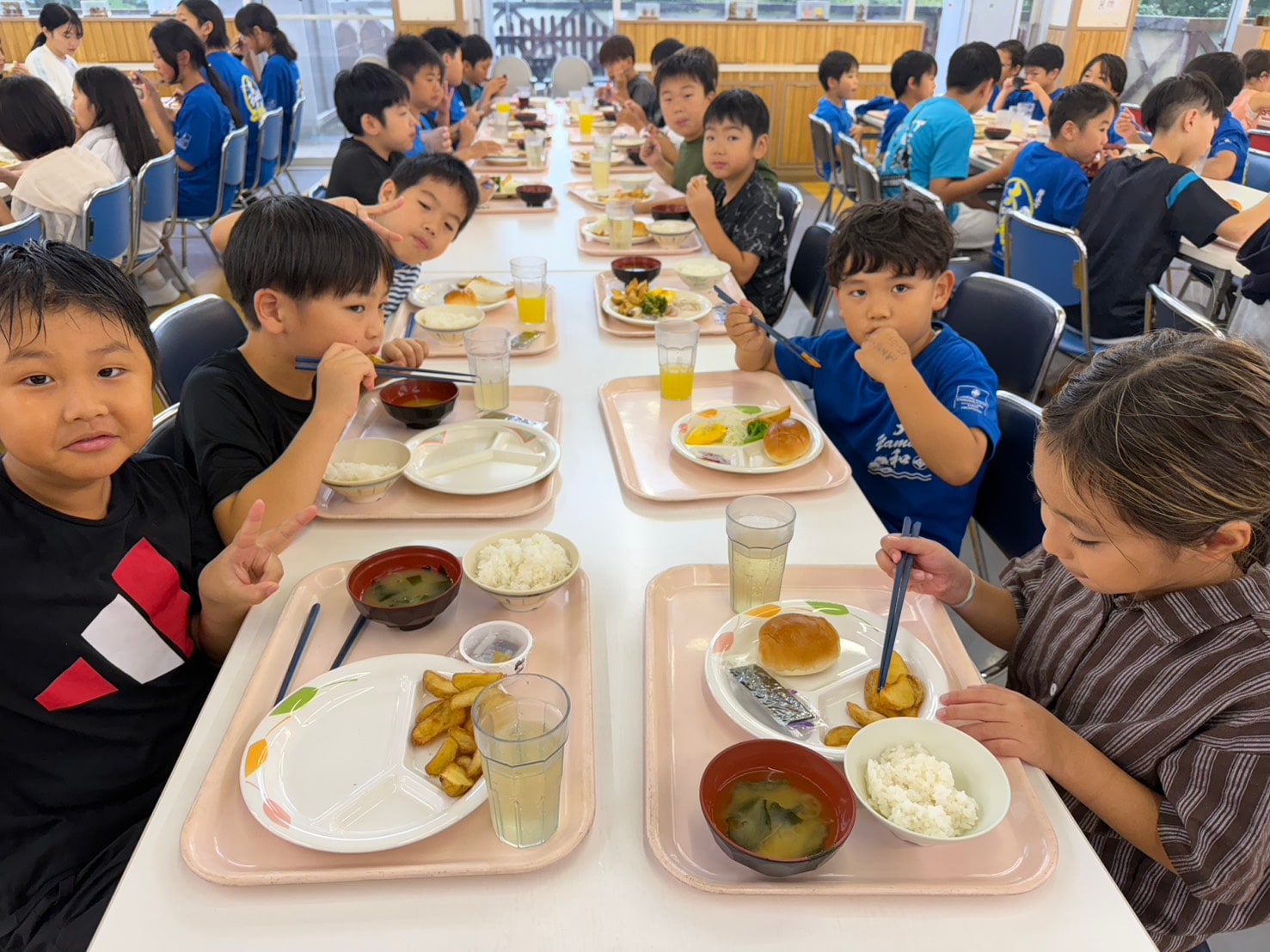 トレーに並んだ朝食を食べる子どもたち