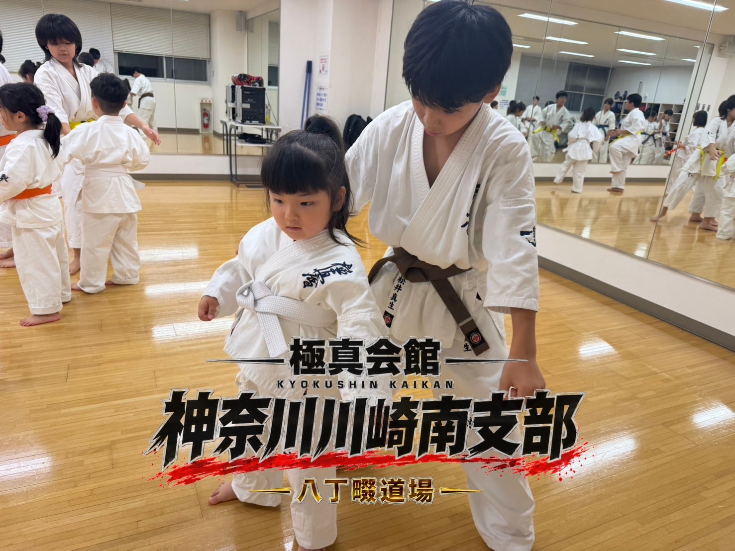 先輩が後輩の姿勢を手を添えて丁寧に直している