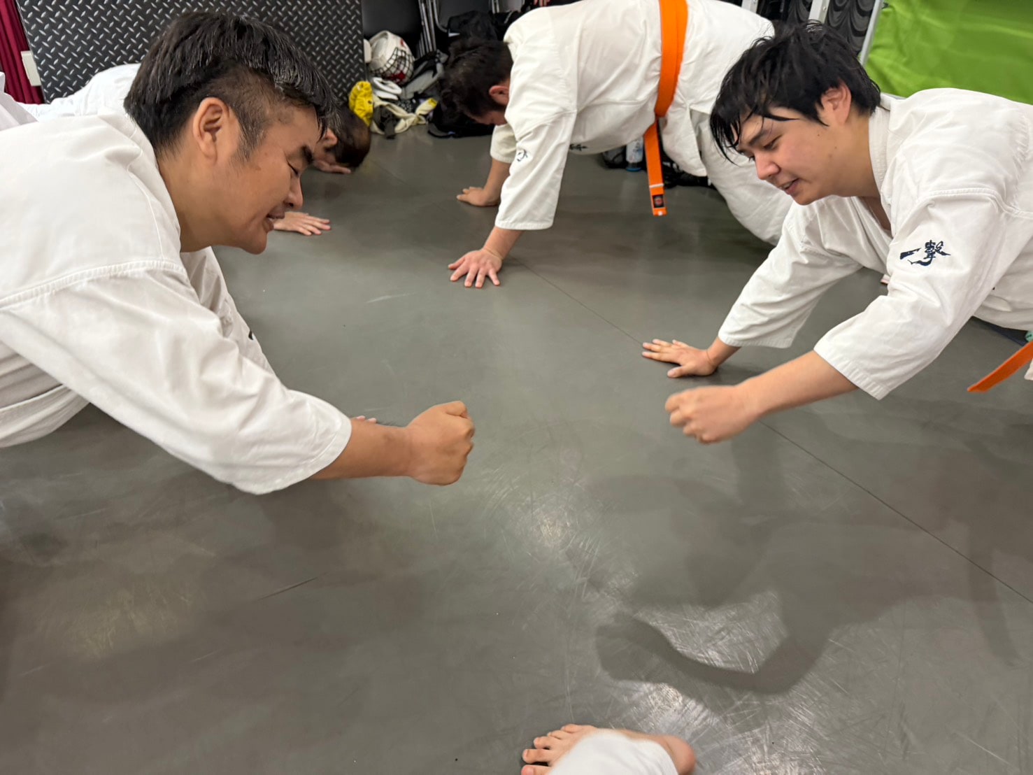 先輩たちが向かい合って腕立て伏せをしながら笑顔を見せている。