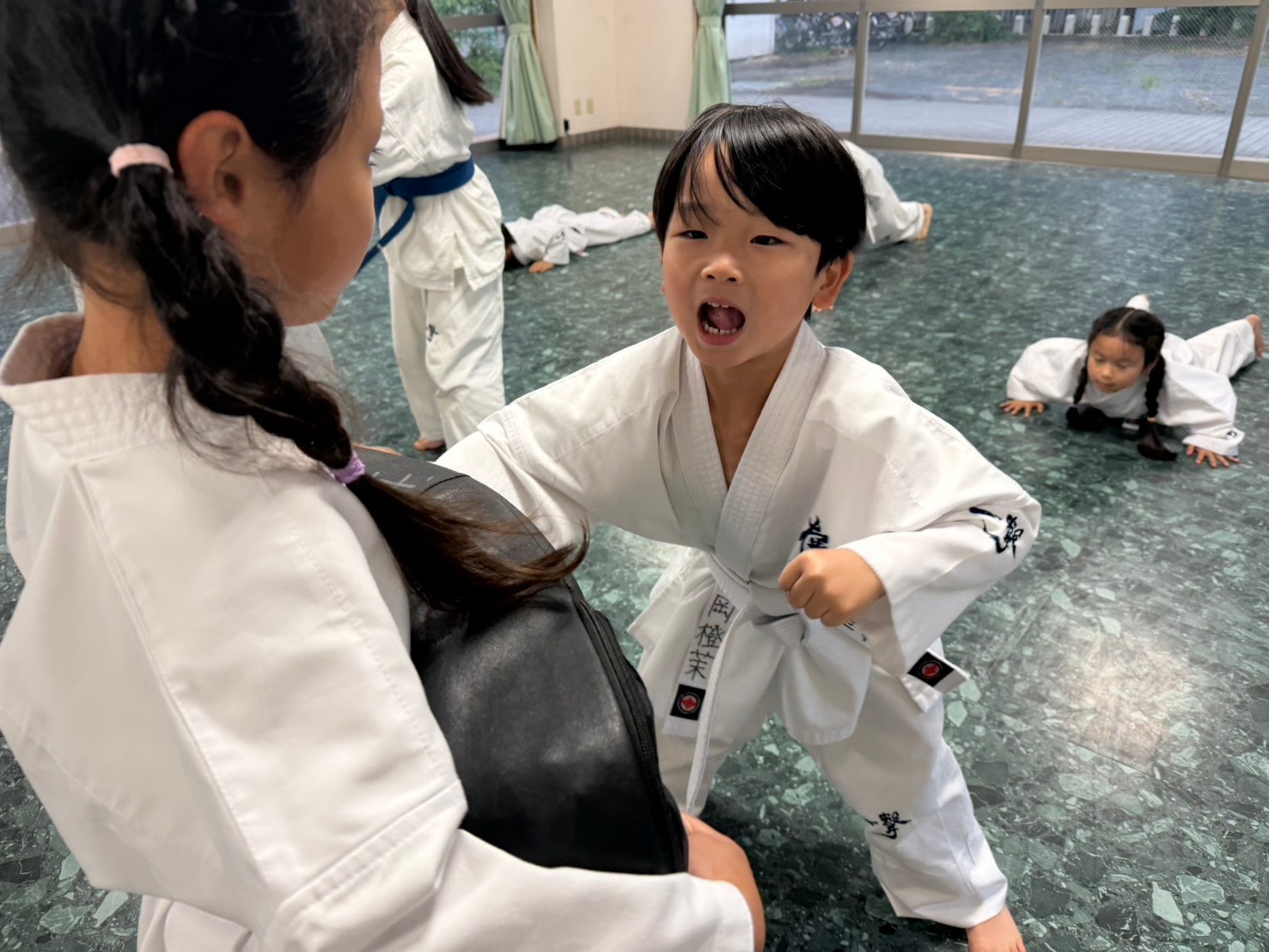 気合いを出しながらミットに突きを打ち込む生徒