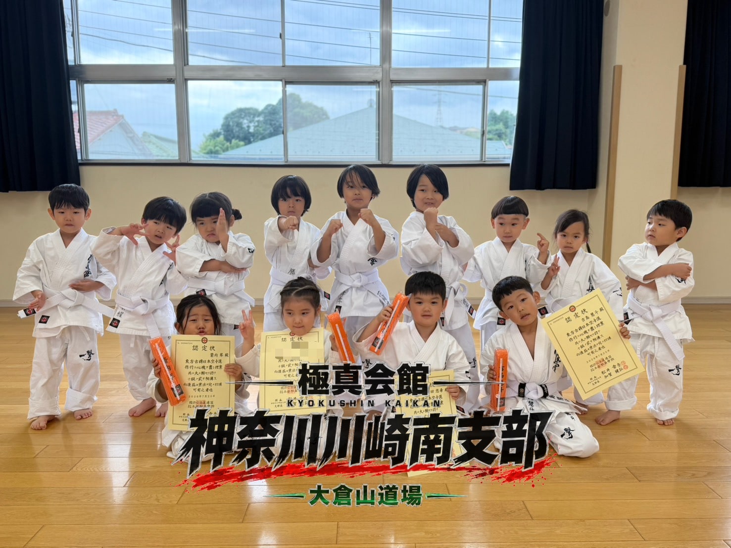 認定状とオレンジ帯を持って記念撮影する子どもたち