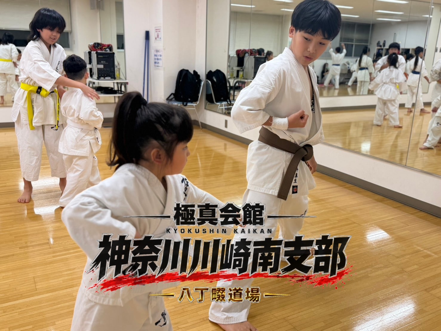 鏡の前で先輩が後輩に手本を示している