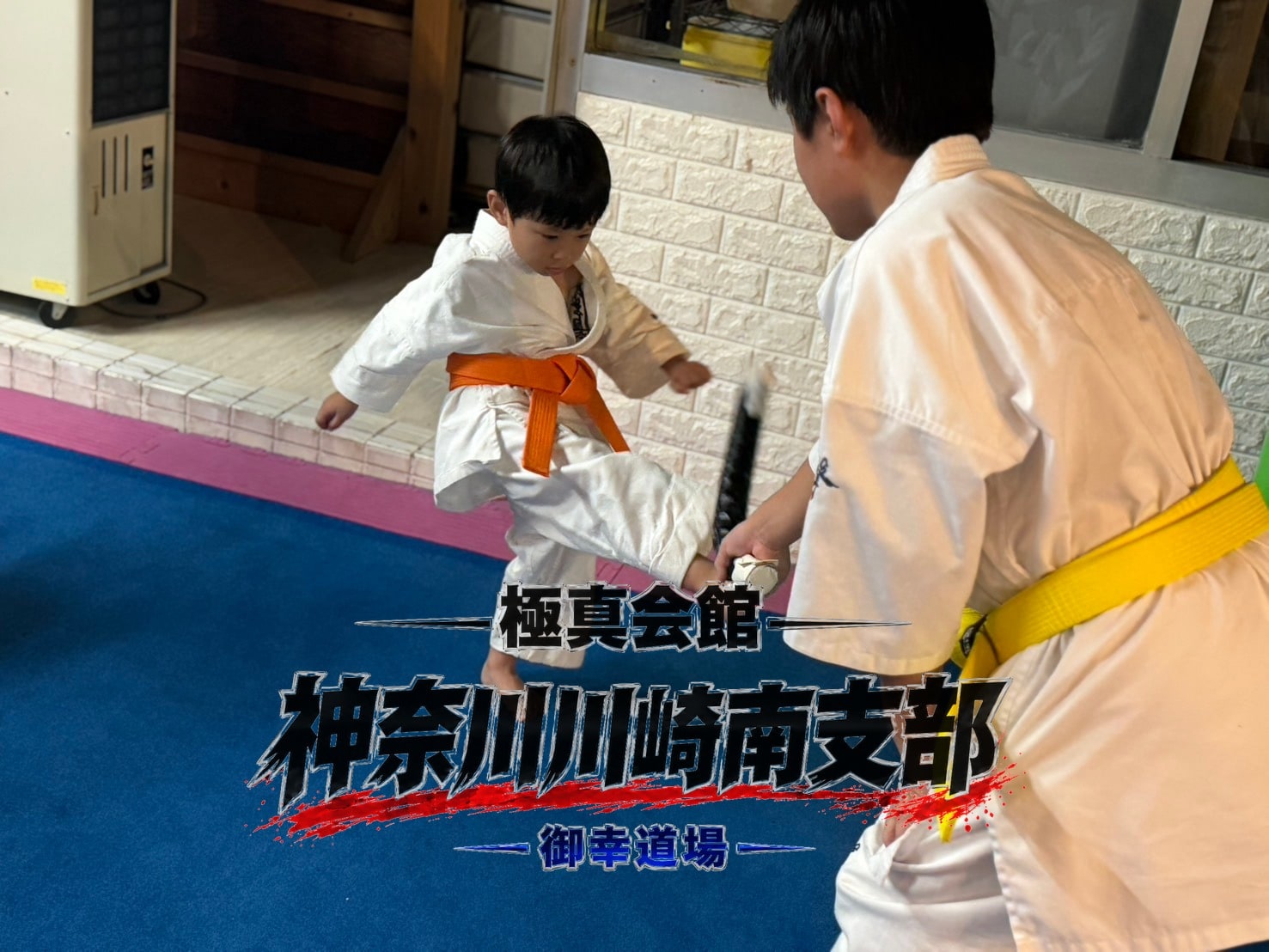 先輩がターゲットを持ち後輩の蹴りをマンツーマンで確認している場面