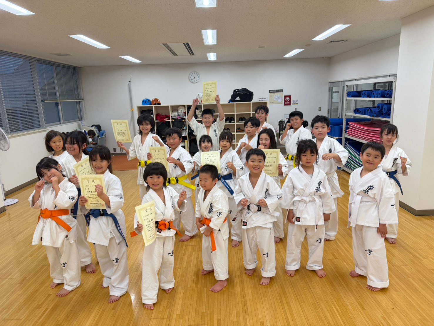 大会の賞状を手に笑顔で集合する幼年・少年クラスの生徒たち