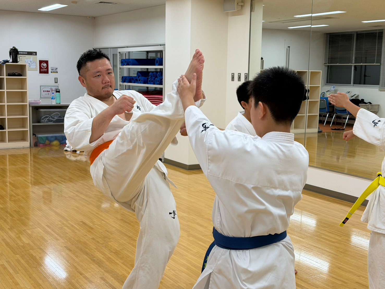 指導員が蹴りの見本を見せる場面