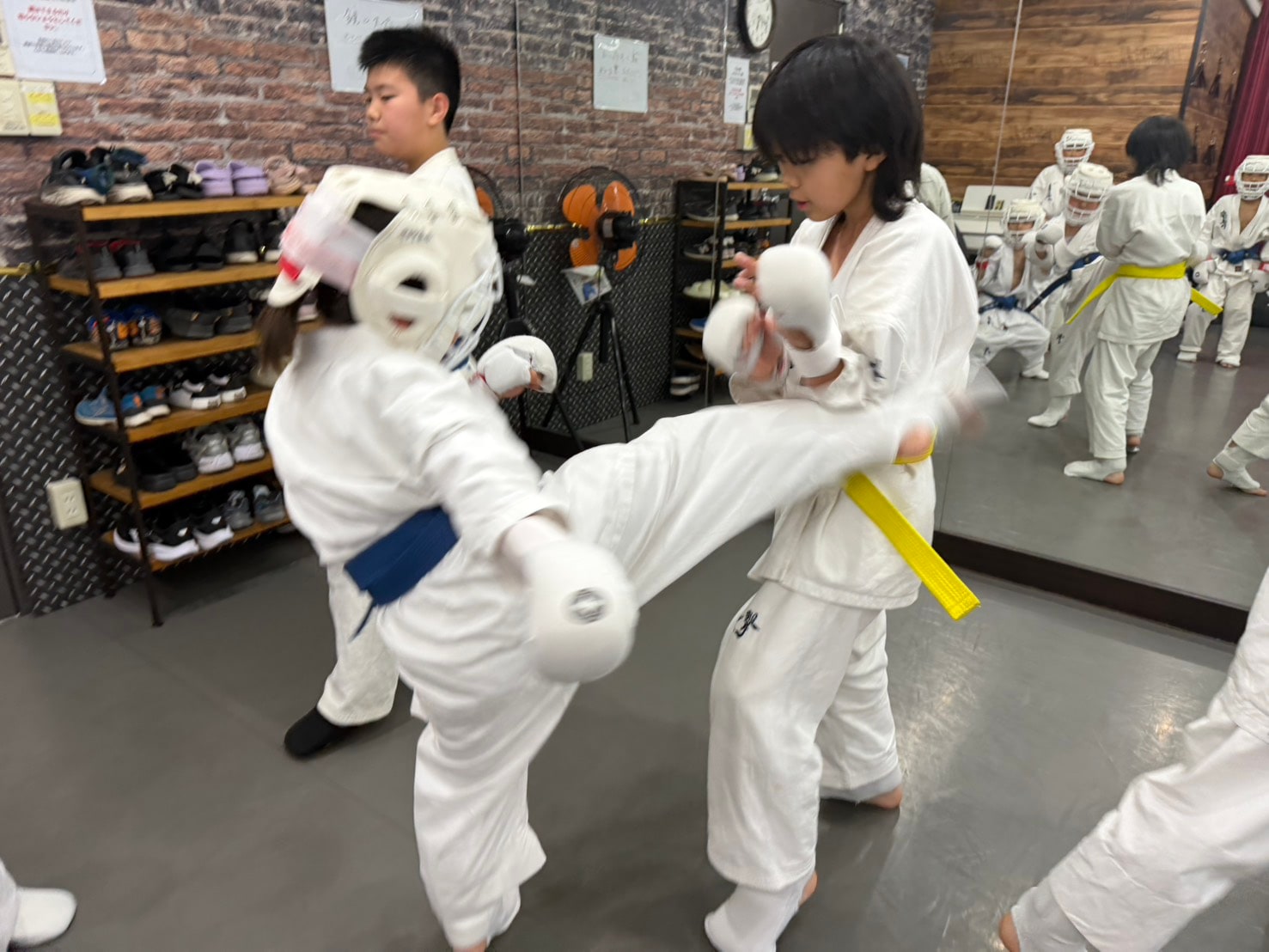 蹴りを出す少年部の組手」loading=