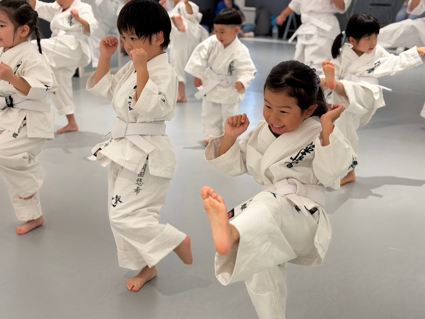 蹴りを高く上げて稽古する少年少女クラス