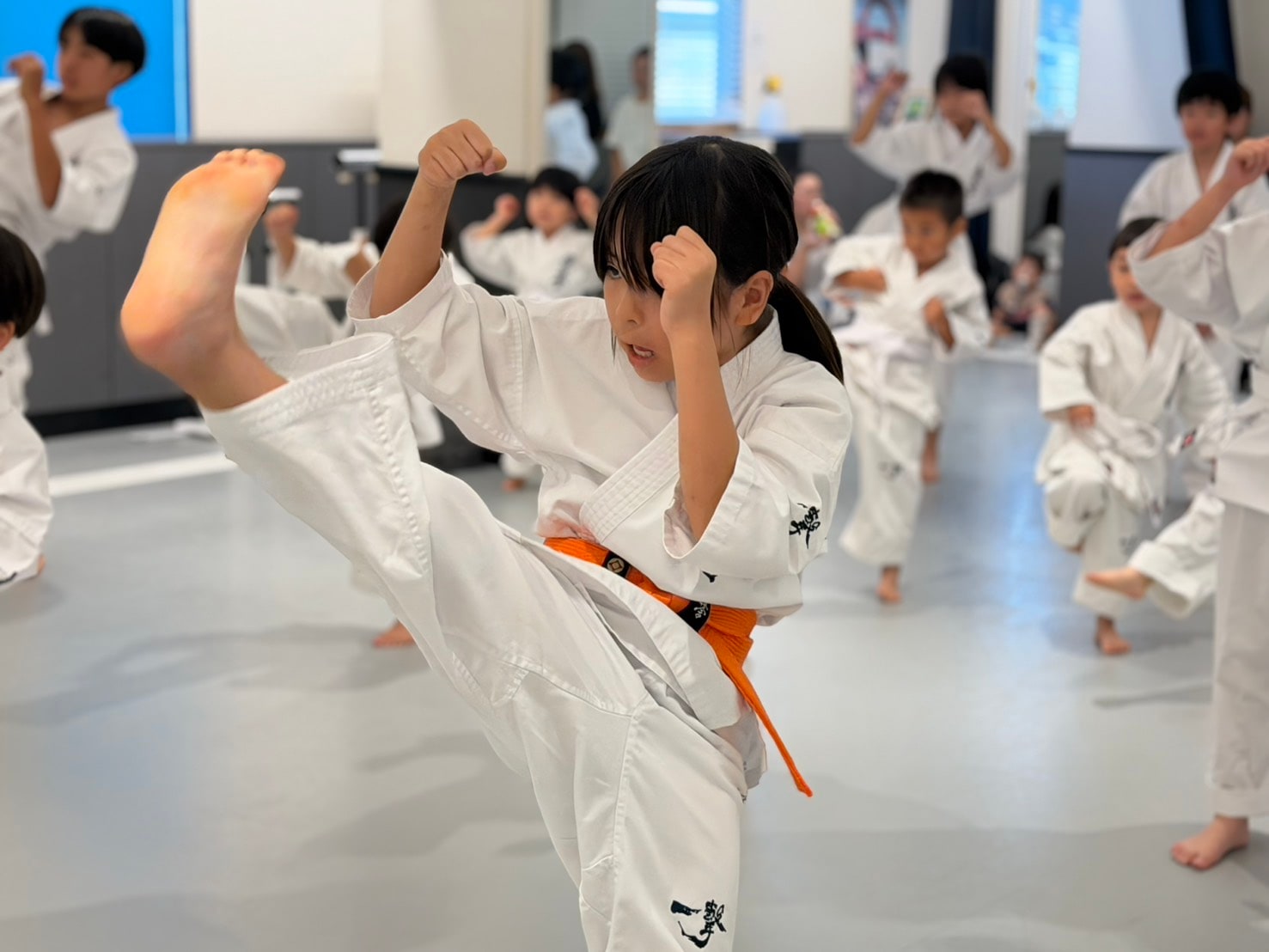 移動稽古で高い蹴りを繰り出すオレンジ帯の道場生