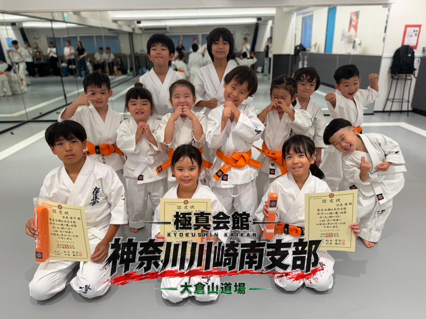 昇級認定を受けた道場生たちが笑顔でポーズ