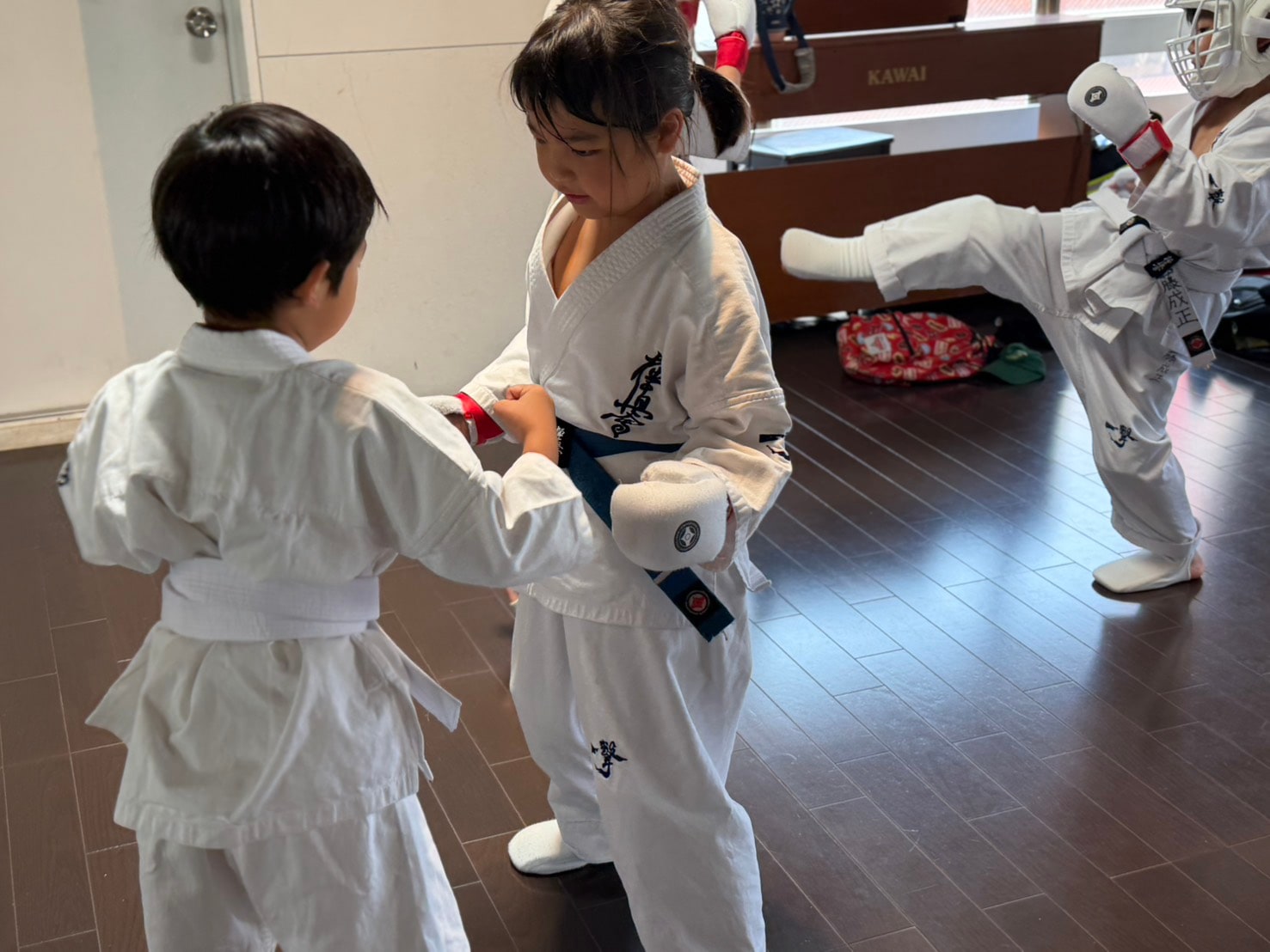 仲間と防具の準備をする道場生