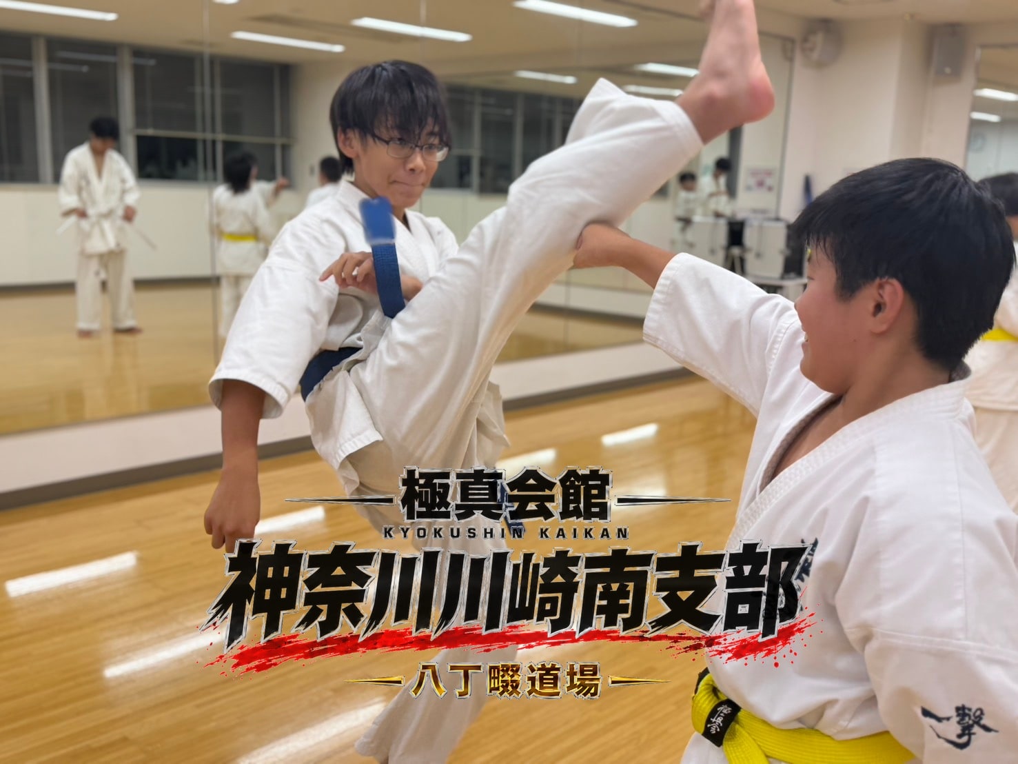 蹴りを蹴り込む道場生とペアの様子