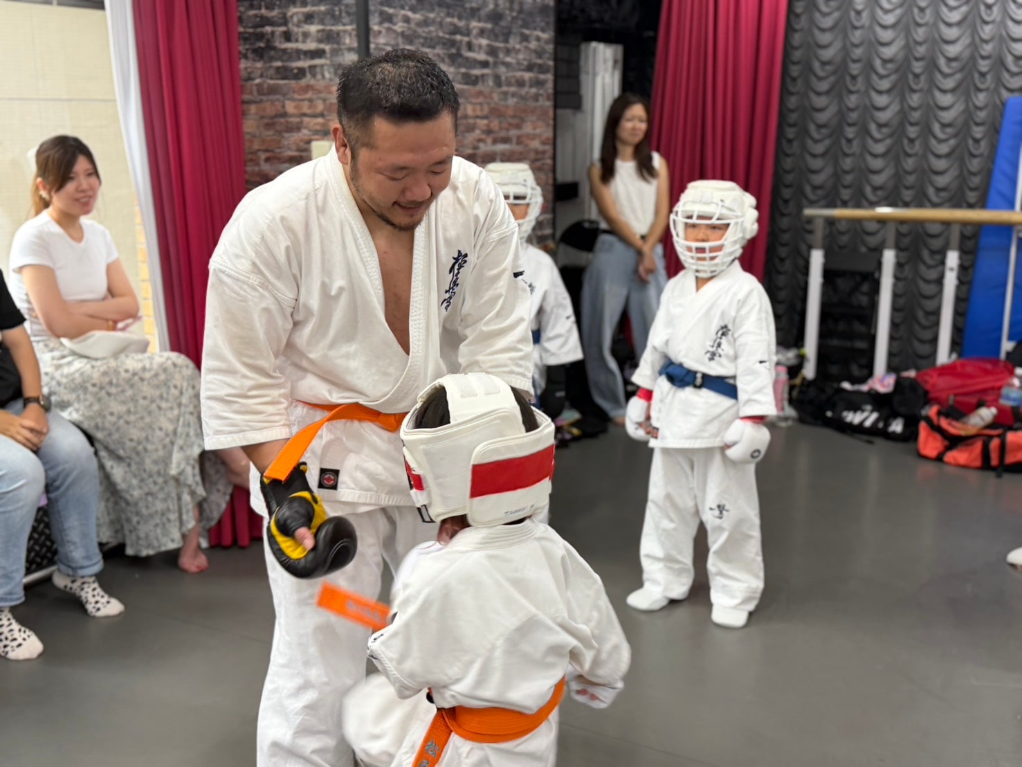 先輩が子どもに組手の指導をしている場面