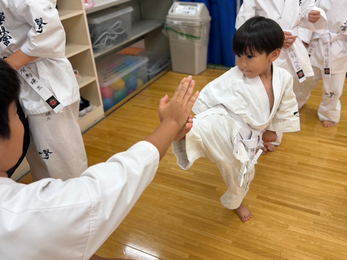 座りながら先輩に蹴りを当てる練習をしている生徒たち