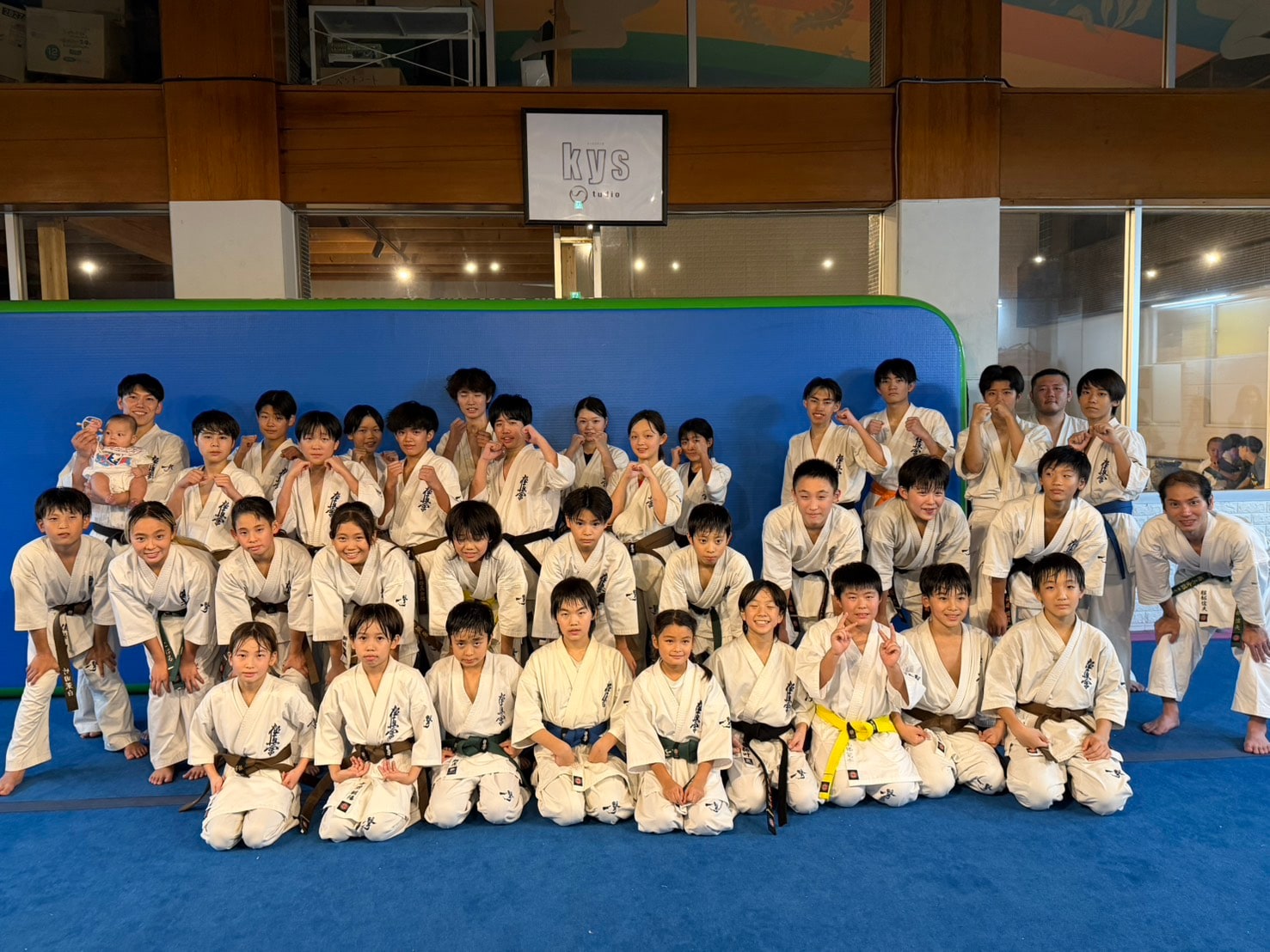 稽古後の全員集合写真。子どもから大人まで約35名以上が笑顔でポーズをとっている