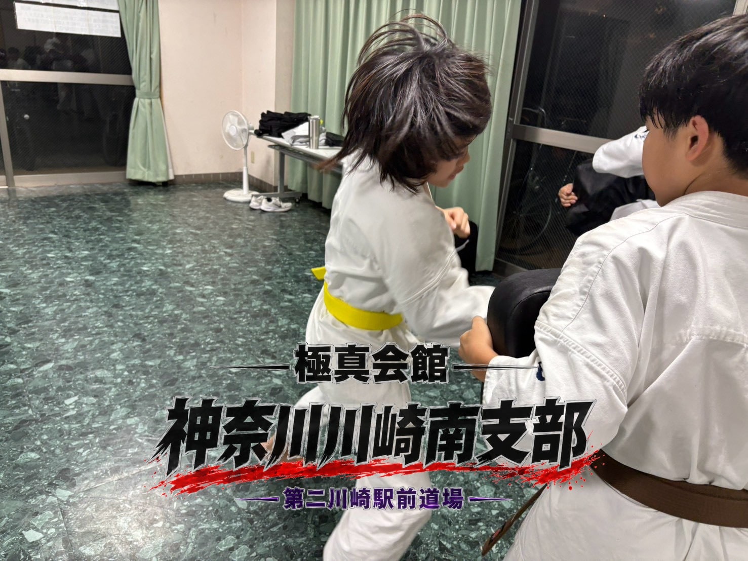 勢いよく蹴りをミットに繰り出す道場生